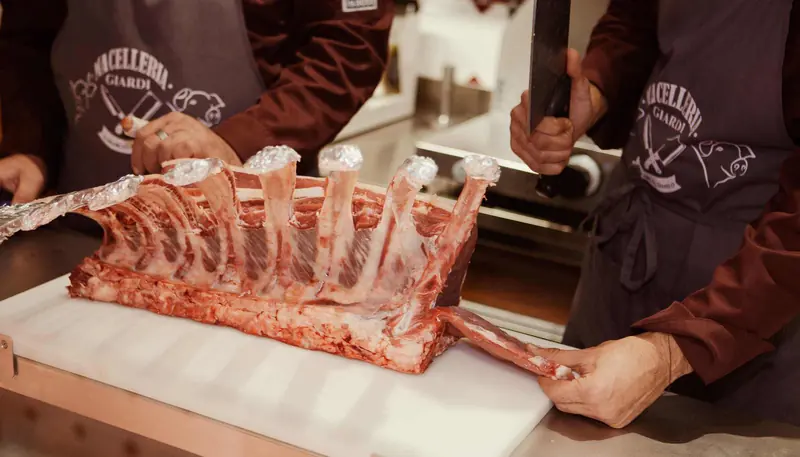 Lavorazione di un carré al banco della macelleria